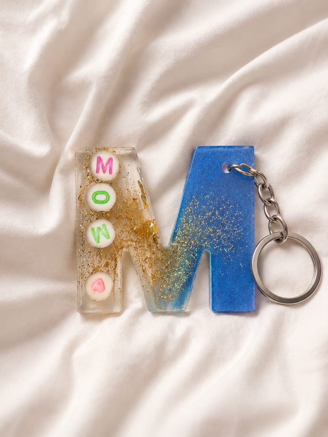 Blue resin M keychain personalised with the name Mona
